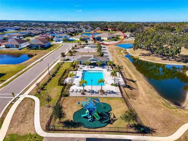 an aerial view of residential houses with outdoor space and parking