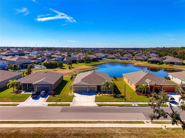 an aerial view of residential houses with outdoor space and swimming pool