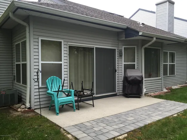 a backyard of a house with glass door and outdoor seating