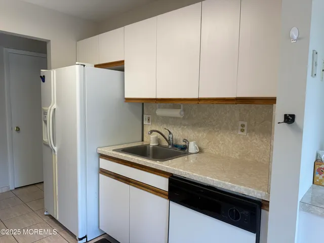 a kitchen with a sink a refrigerator and cabinets