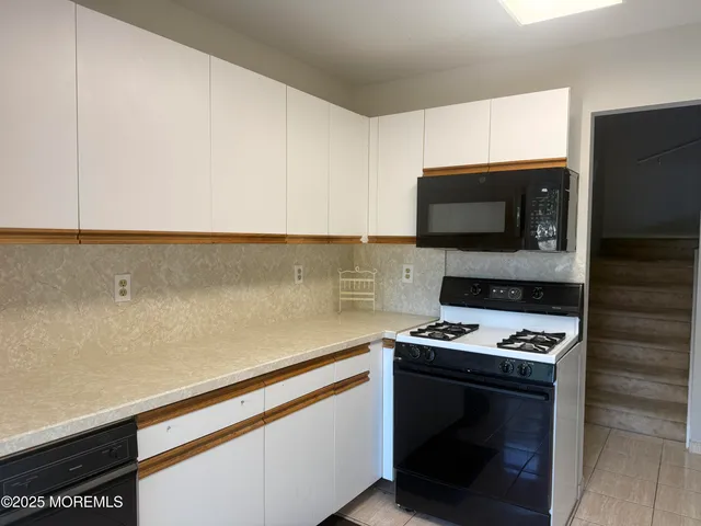 a kitchen with appliances a sink and cabinets