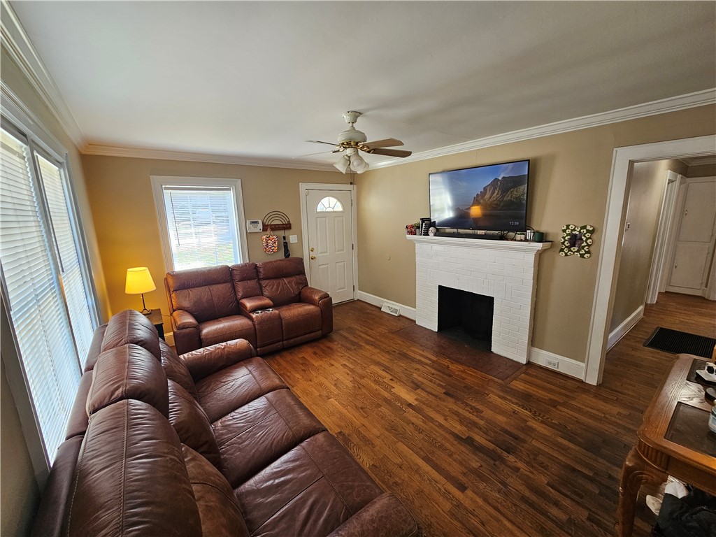 237 Pine Lane Anderson, SC 29621 - Photo 9 of 22 This living room features rich wood flooring, a charming fireplace, and abundant natural light.