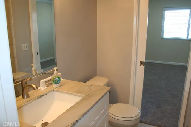 a bathroom with a sink toilet vanity and shower