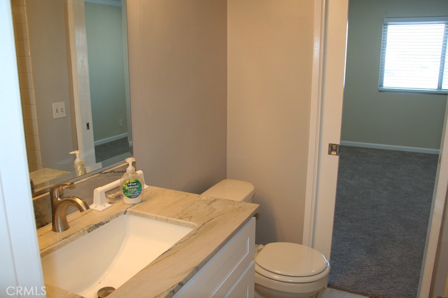 17140 Bluewater Lane, Unit 154 Huntington Beach, CA 92649 - Photo 13 of 28 a bathroom with a sink toilet vanity and shower