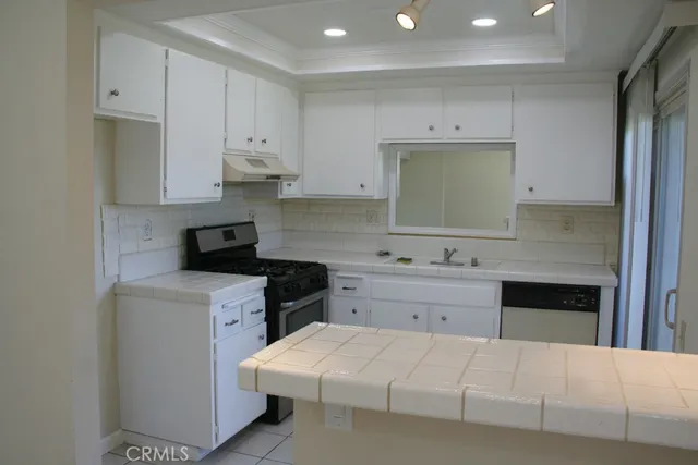 a kitchen with a white stove top oven sink and cabinets