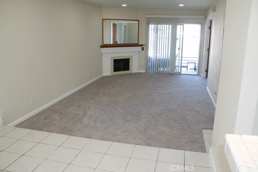 17140 Bluewater Lane, Unit 154 Huntington Beach, CA 92649 - Photo 4 of 28 a view of an empty room with a fireplace and a window