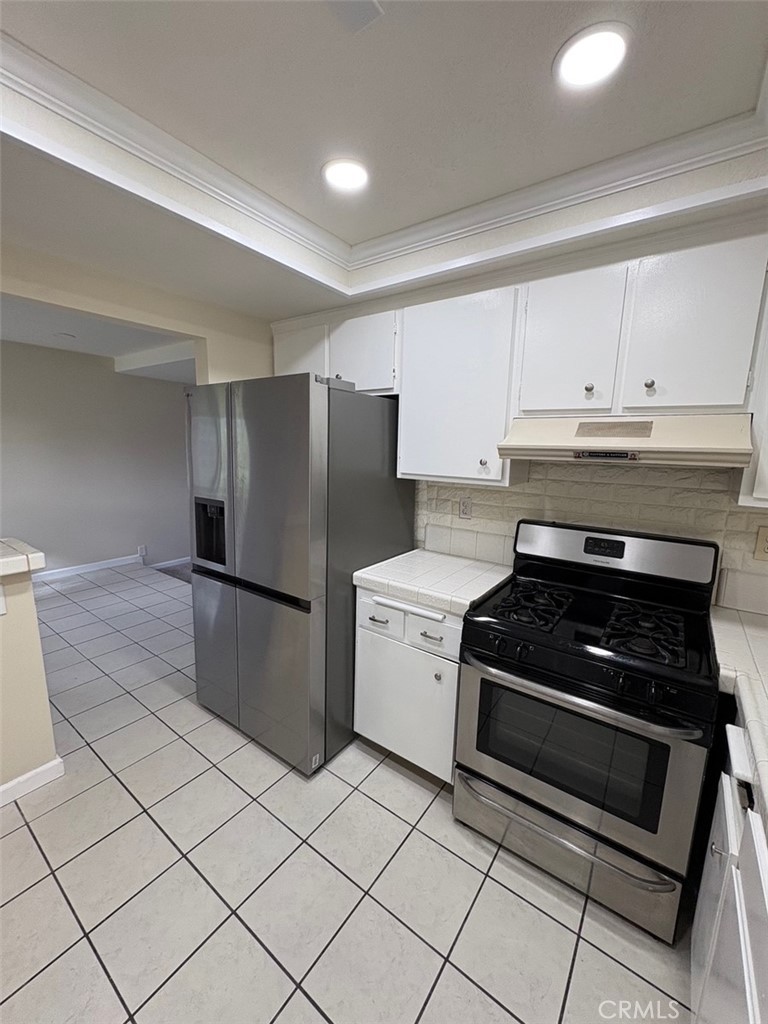 17140 Bluewater Lane, Unit 154 Huntington Beach, CA 92649 - Photo 6 of 28 a kitchen with a stove top oven and cabinets