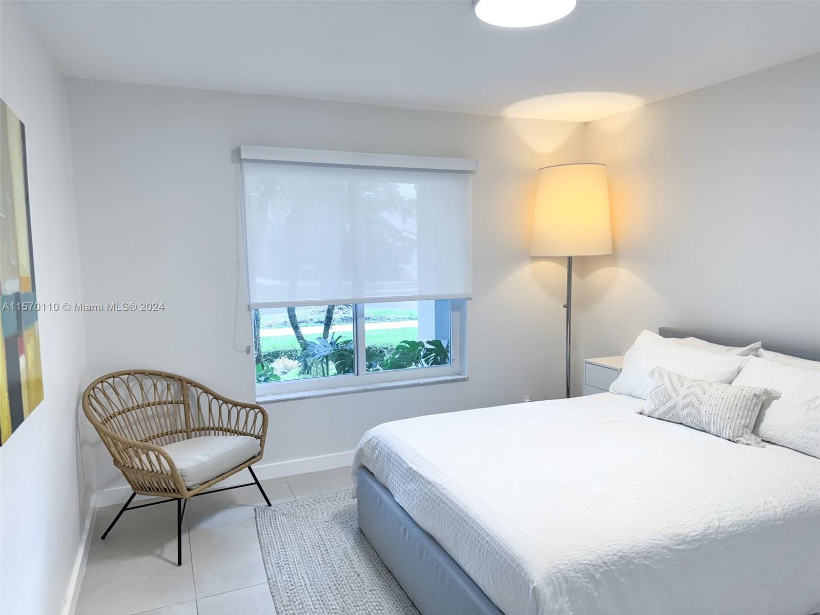 1945 Lakeshore Drive Weston, FL 33326 - Photo 14 of 19 a bedroom with a bed a lamp and a large window