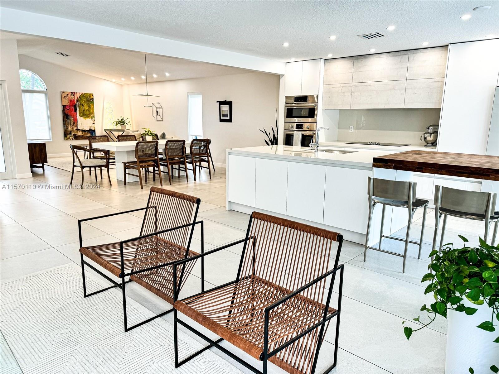 1945 Lakeshore Drive Weston, FL 33326 - Photo 5 of 19 a kitchen with stainless steel appliances kitchen island granite countertop a table chairs sink and cabinets