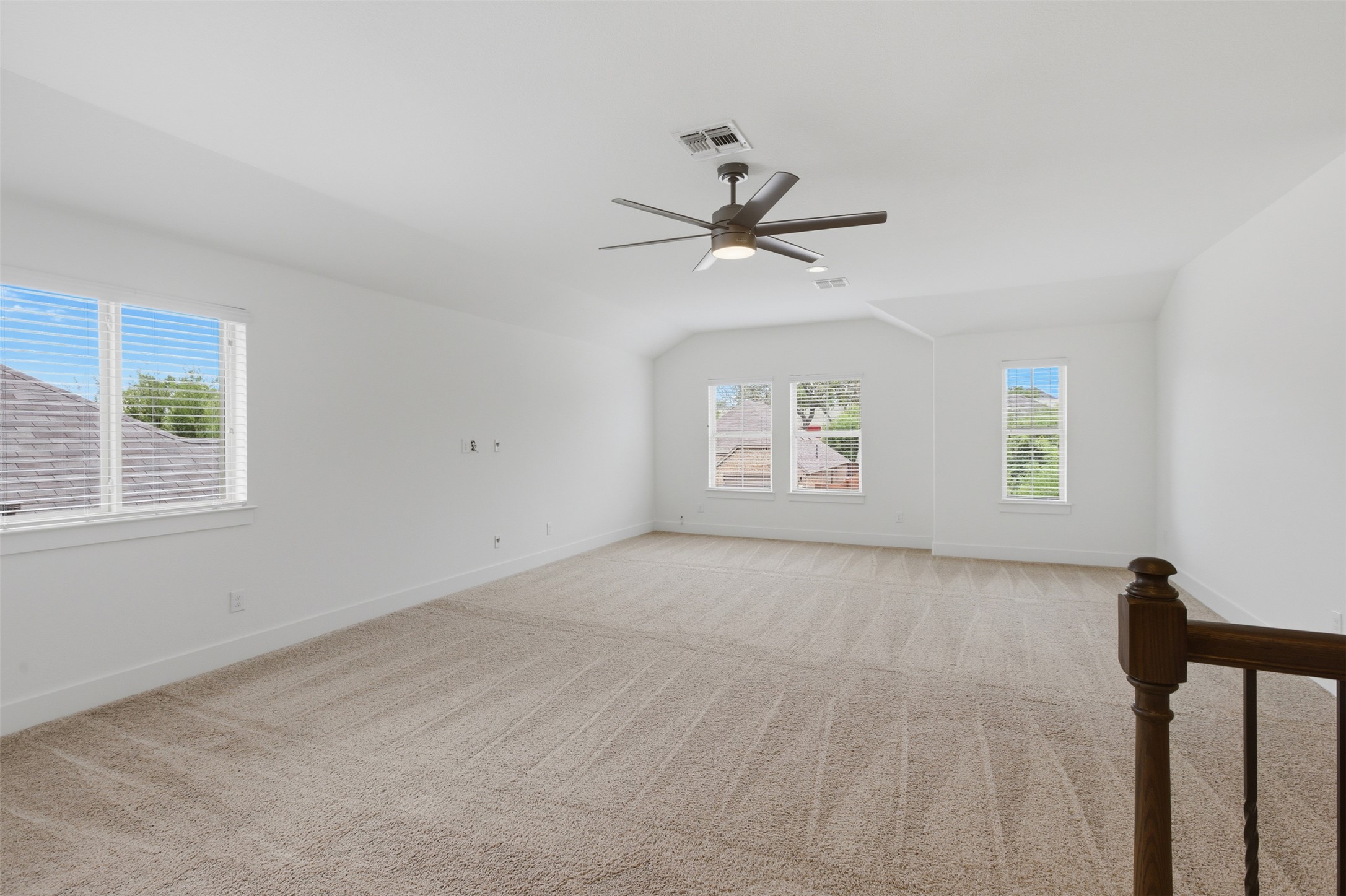 2004 Garretts Way Manchaca, TX 78652 - Photo 14 of 24 Empty room featuring vaulted ceiling, light carpet, and a ceiling fan