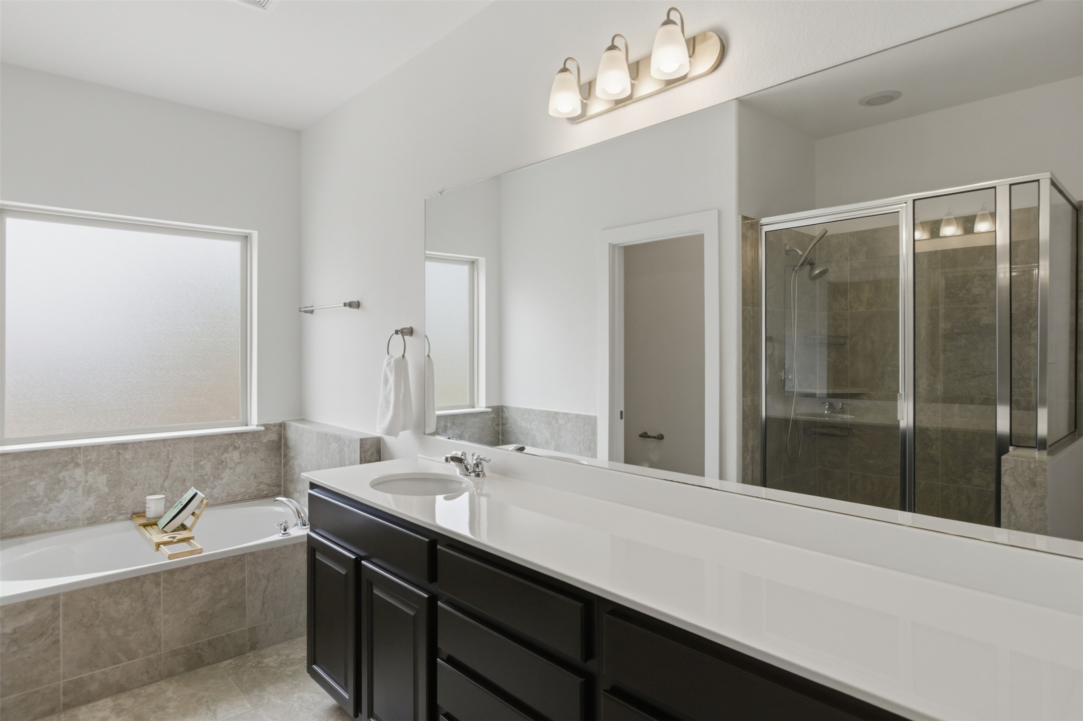 2004 Garretts Way Manchaca, TX 78652 - Photo 20 of 37 Full bath with a bath, a shower stall, vanity, and light tile patterned floors