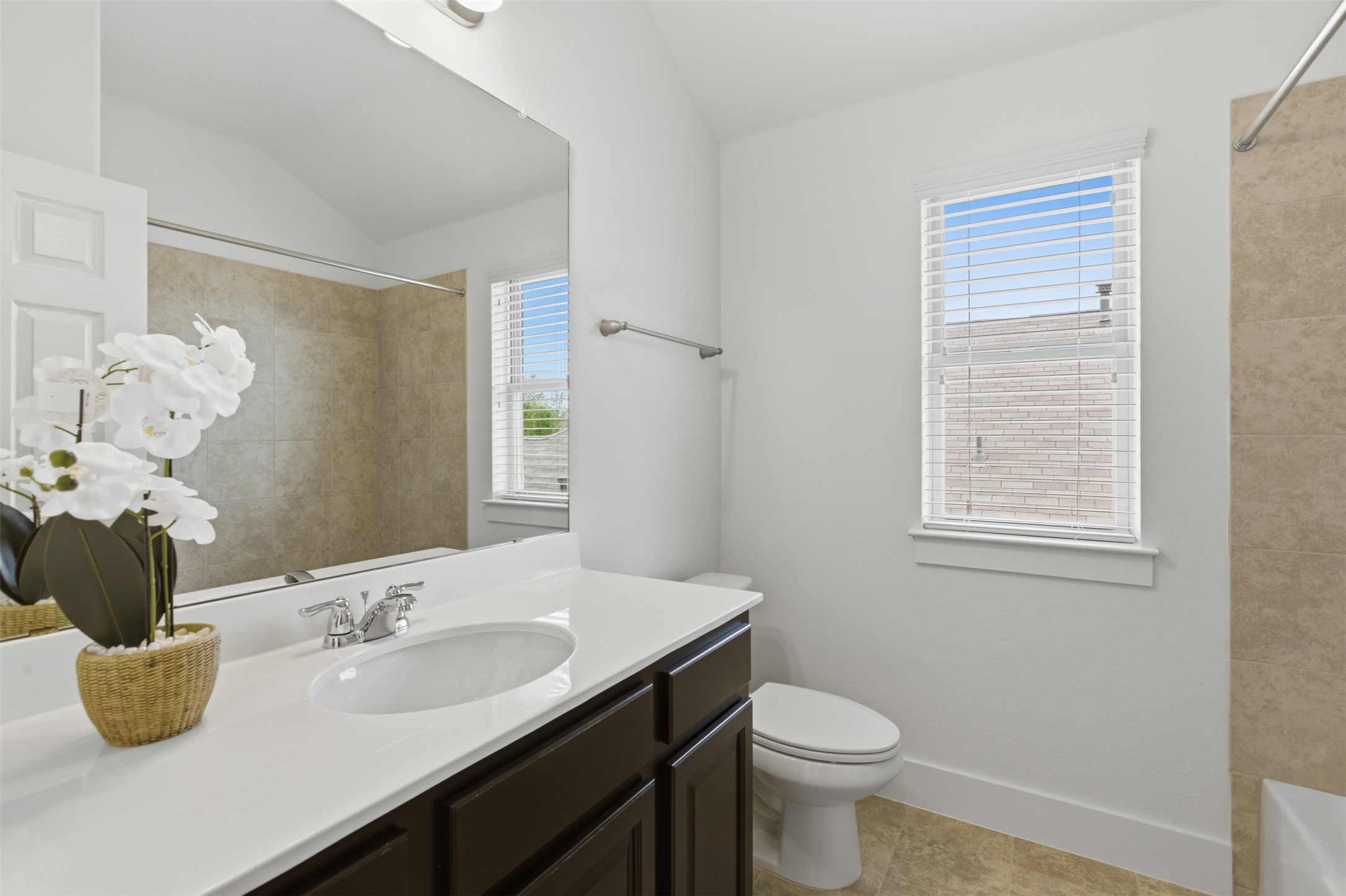 2004 Garretts Way Manchaca, TX 78652 - Photo 28 of 37 Full bath featuring vanity, vaulted ceiling, light tile patterned flooring, and shower / bathtub combination