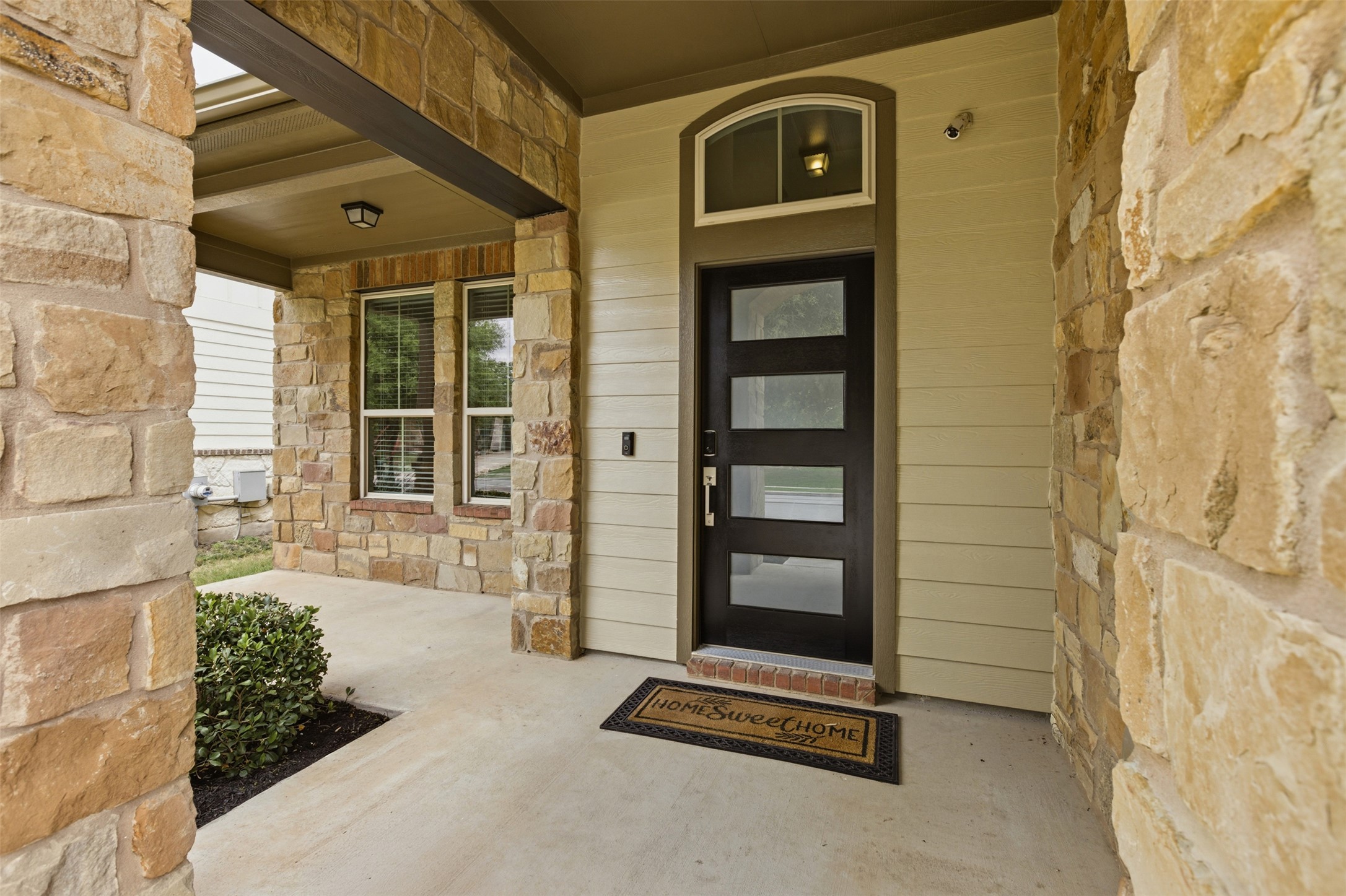 2004 Garretts Way Manchaca, TX 78652 - Photo 3 of 24 Doorway to property featuring stone siding and covered porch