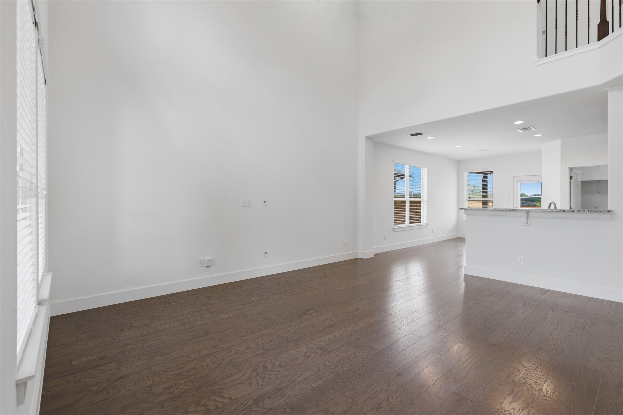 2004 Garretts Way Manchaca, TX 78652 - Photo 7 of 24 Unfurnished living room featuring a high ceiling, dark wood-style flooring, and recessed lighting