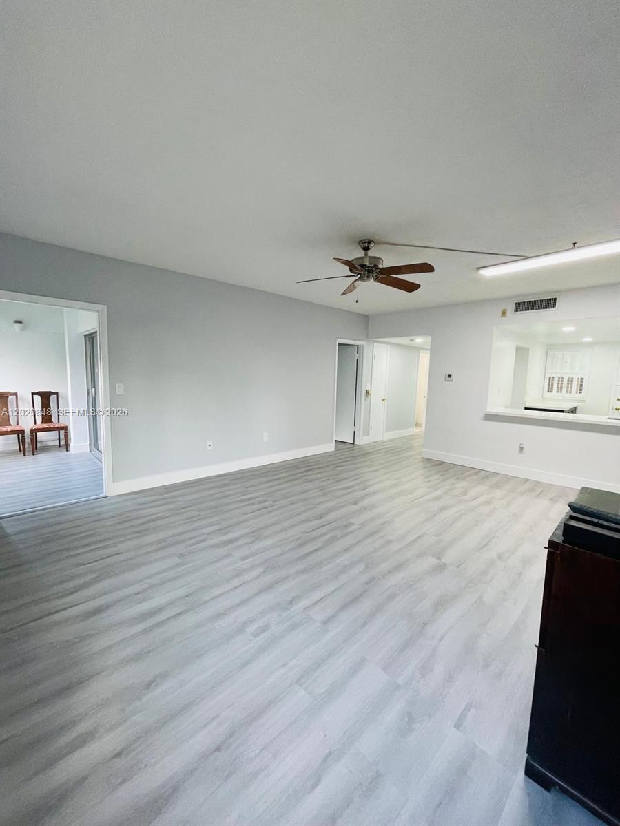 9175 Southwest 77th Avenue, Unit 306 Miami, FL 33156 - Photo 3 of 16 a view of a livingroom with wooden floor and a flat screen tv