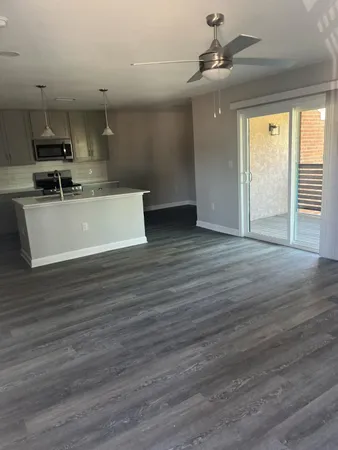 a view of kitchen with stainless steel appliances wooden floor large window and wooden floor