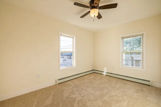 an empty room with windows and fan