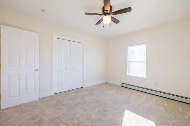 an empty room with a window and a fan