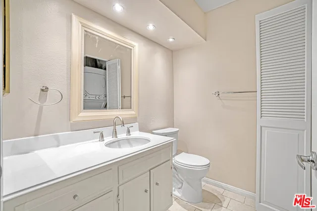 a bathroom with a granite countertop sink a toilet and shower