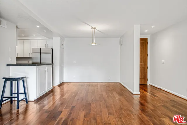 a view of a kitchen with wooden floor and a window