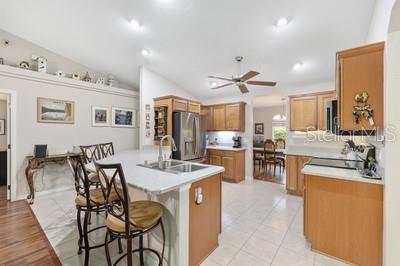 12351 Southwest 73rd Street Ocala, FL 34481 - Photo 16 of 77 a kitchen with stainless steel appliances kitchen island granite countertop a table chairs and a refrigerator
