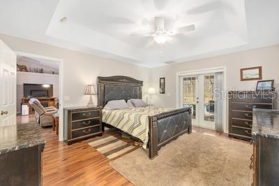 12351 Southwest 73rd Street Ocala, FL 34481 - Photo 21 of 77 a bedroom with a bed and a chandelier