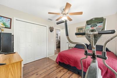 12351 Southwest 73rd Street Ocala, FL 34481 - Photo 27 of 77 a bedroom with a bed a flat screen tv and a chandelier