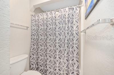 12351 Southwest 73rd Street Ocala, FL 34481 - Photo 32 of 77 a white toilet sitting next to a shower curtain