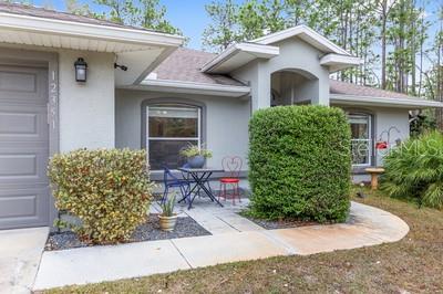 12351 Southwest 73rd Street Ocala, FL 34481 - Photo 8 of 77 a front view of a house with garden