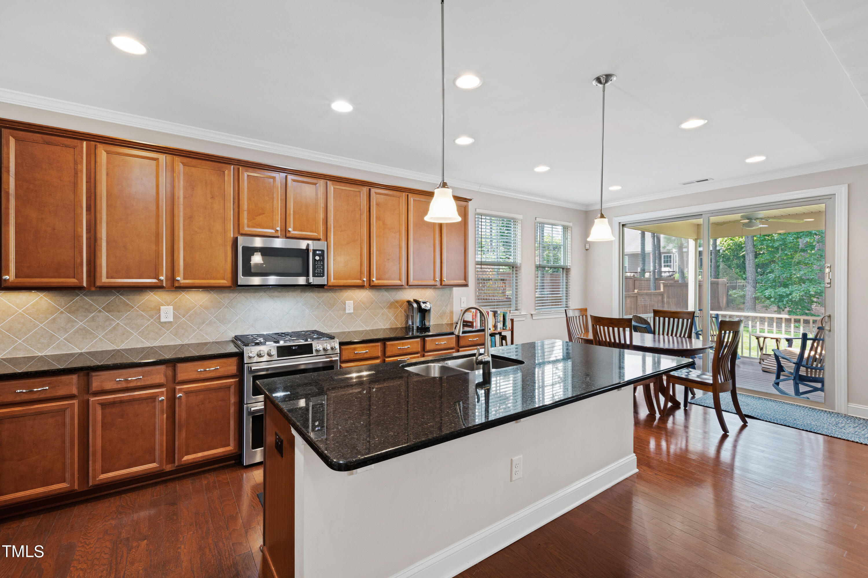 6004 Clapton Drive Wake Forest, NC 27587 - Photo 17 of 52 a kitchen with stainless steel appliances granite countertop a sink a stove and a wooden floors