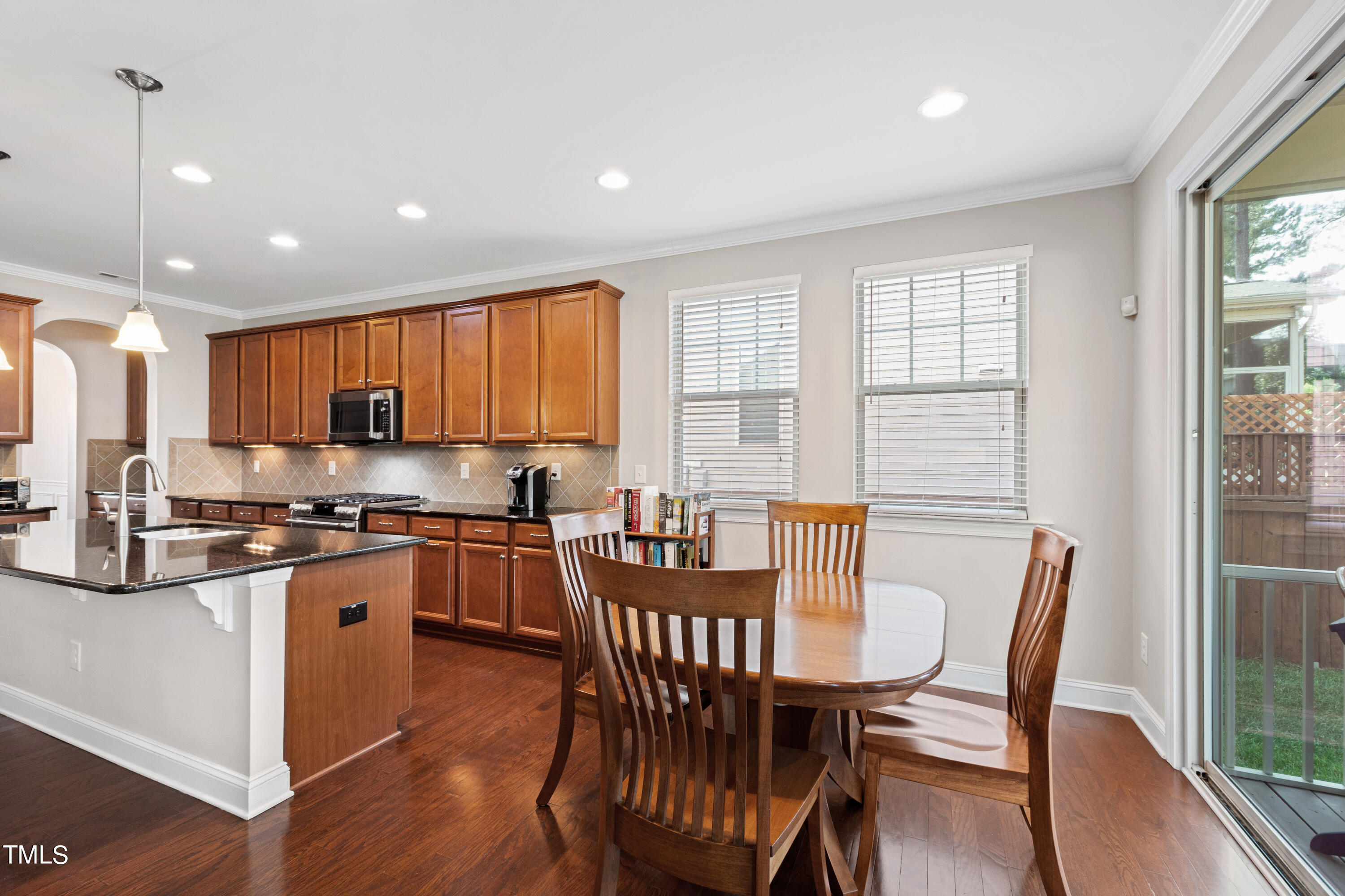 6004 Clapton Drive Wake Forest, NC 27587 - Photo 18 of 52 a kitchen with stainless steel appliances granite countertop a stove a refrigerator a kitchen island with a dining table and chairs