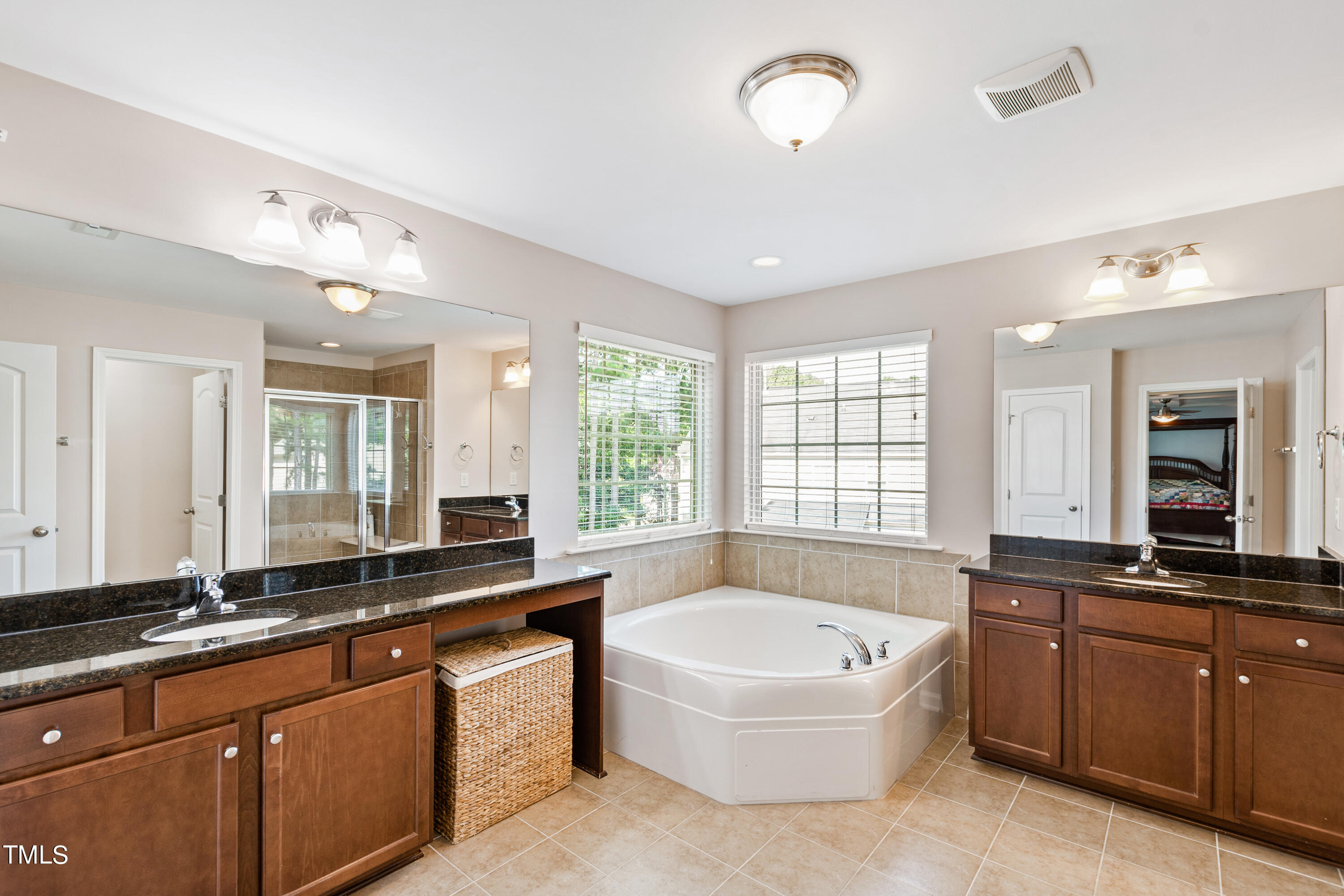 6004 Clapton Drive Wake Forest, NC 27587 - Photo 33 of 52 a large bathroom with a large tub sink and mirror