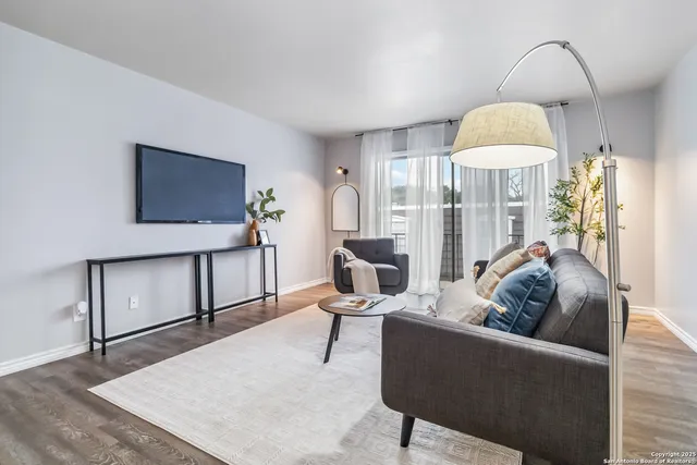 a living room with furniture and a wooden floor