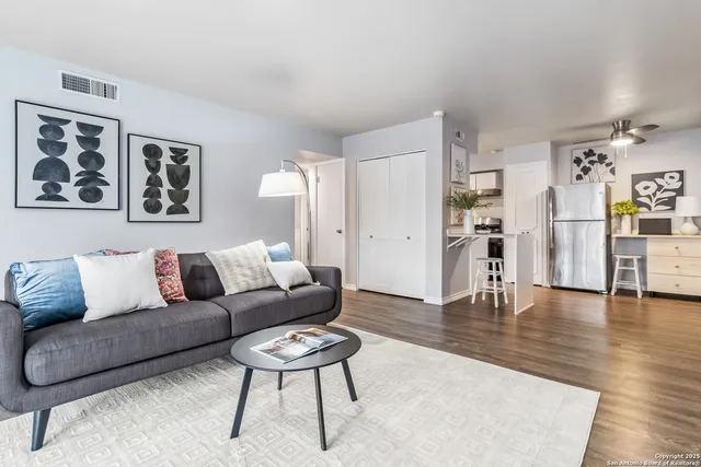 a living room with furniture and wooden floor