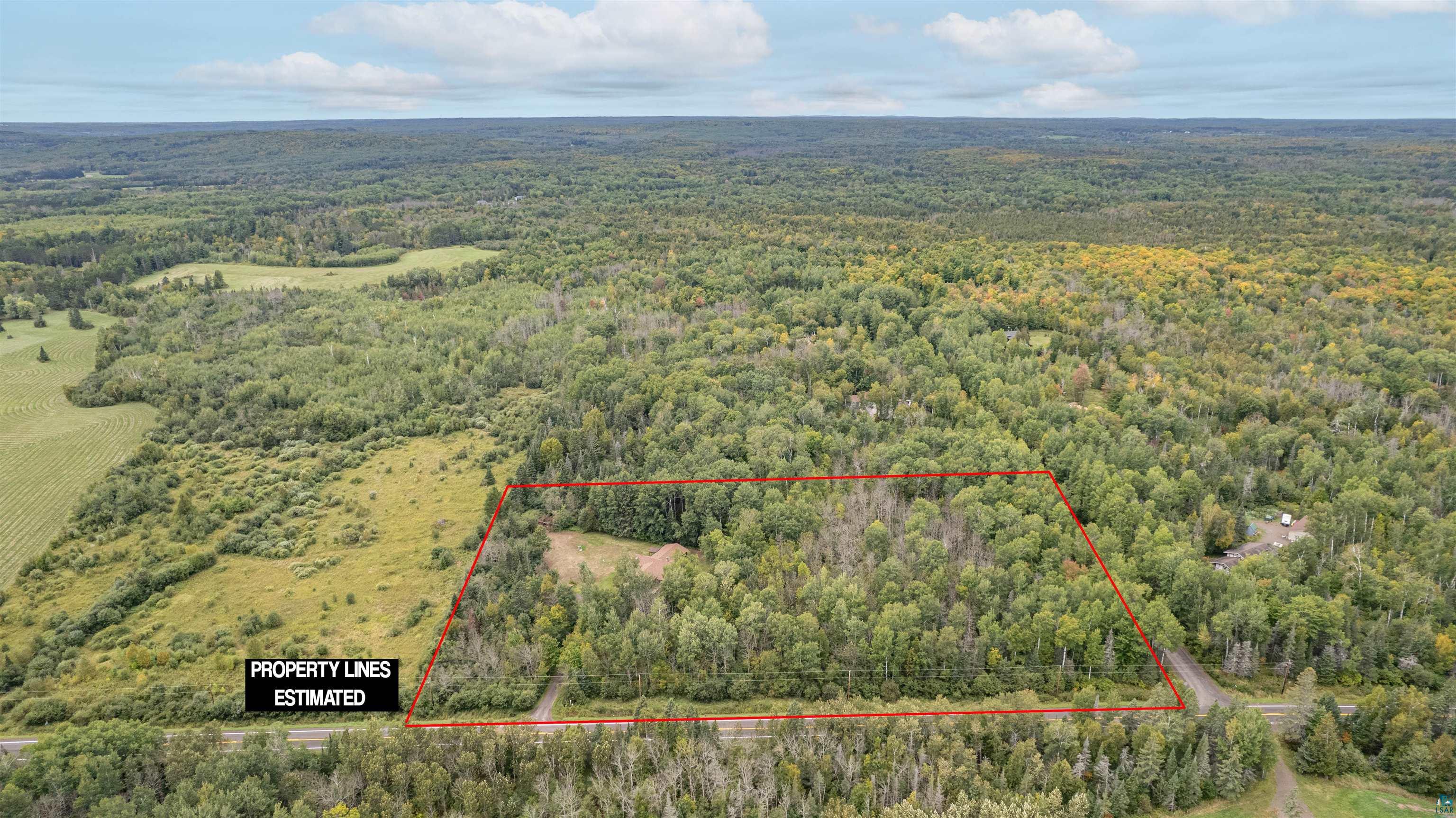 5373 Lester River Road Duluth, MN 55804 - Photo 37 of 39 Expansive undeveloped land featuring mature trees and a cleared area, bordered by a paved road