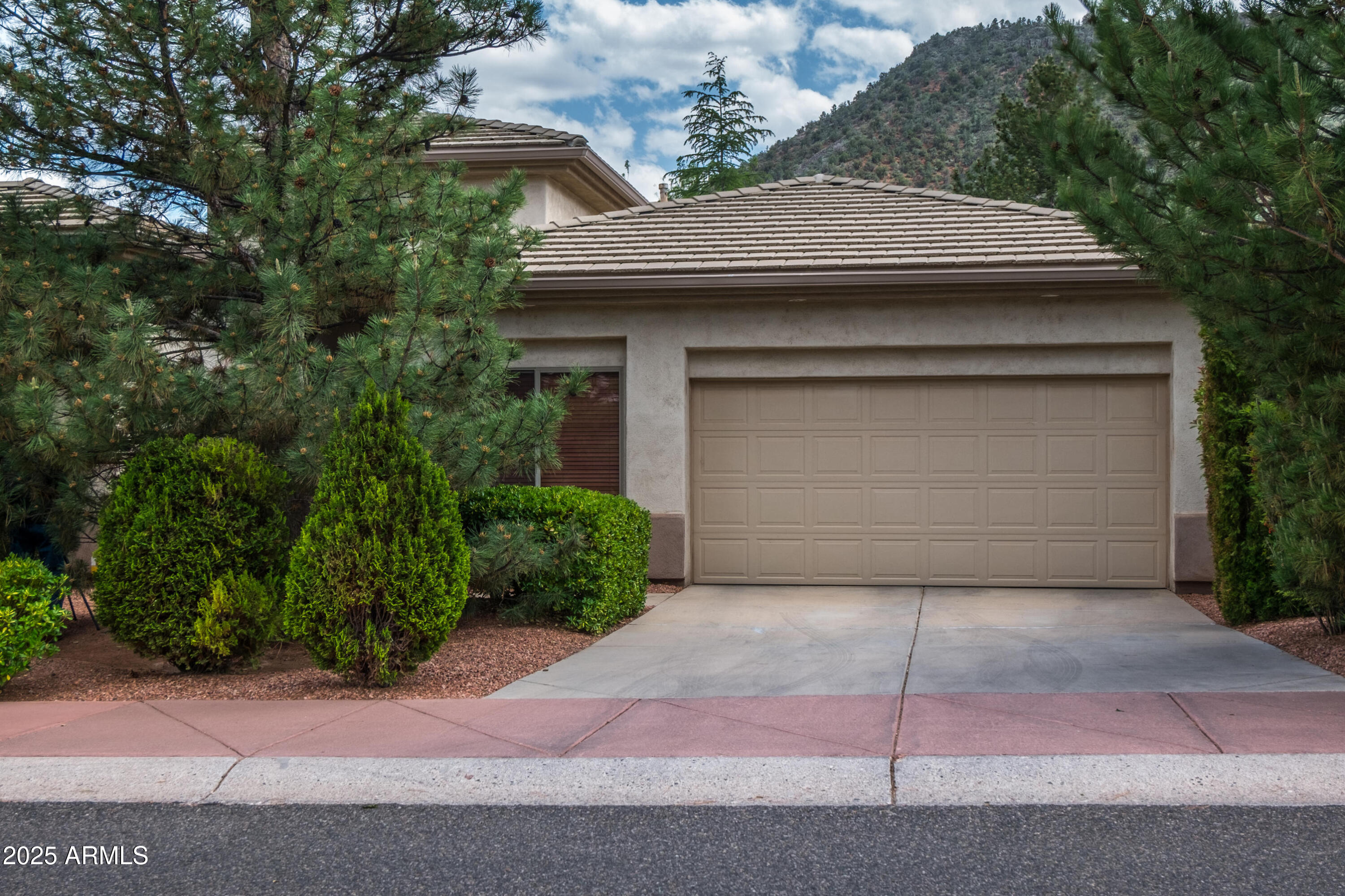 722 Crown Ridge Road Sedona, AZ 86351 - Photo 34 of 35 a front view of a house with a yard and garage