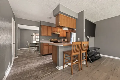 a kitchen with a table chairs refrigerator and cabinets