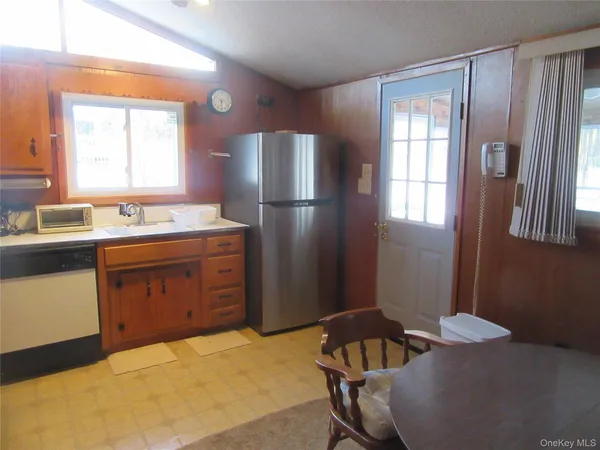a kitchen with a sink refrigerator and window