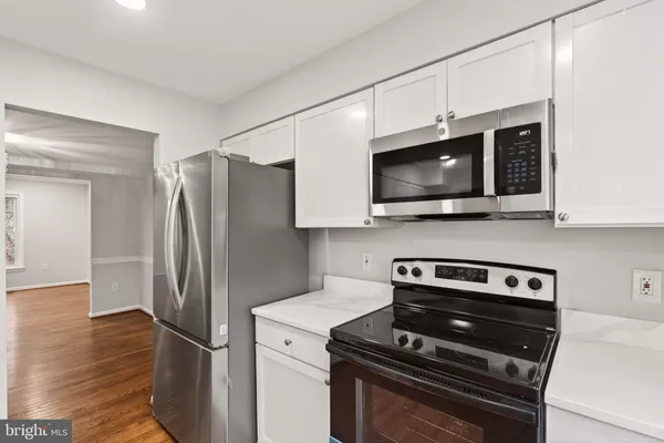 a kitchen with stainless steel appliances a stove microwave and refrigerator