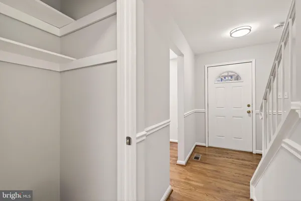 a view of a hallway with wooden floor and closet