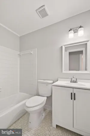 a bathroom with a toilet a sink a mirror and bathtub