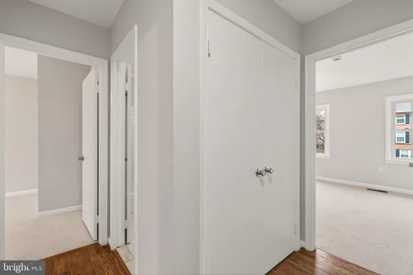 a view of a hallway with wooden floor and closet area