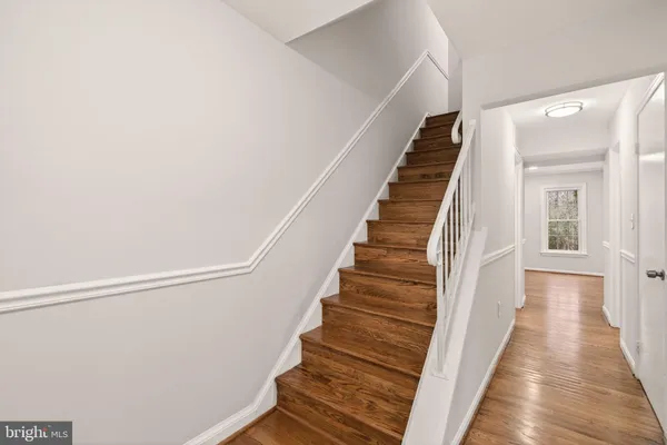 a view of a hallway with wooden floor and entryway