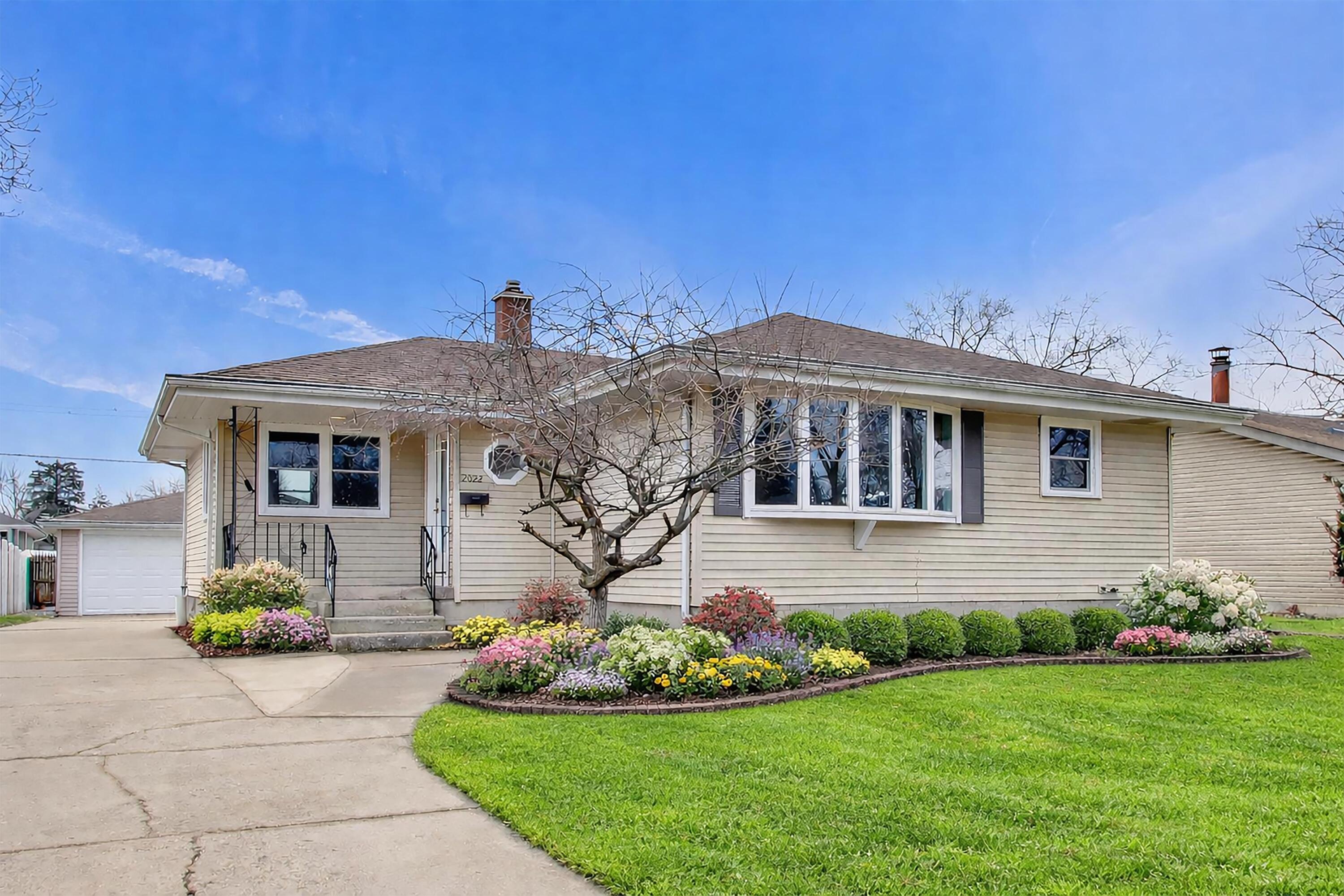 2022 38th Street Highland, IN 46322 - Photo 1 of 41 a front view of a house with a garden and yard