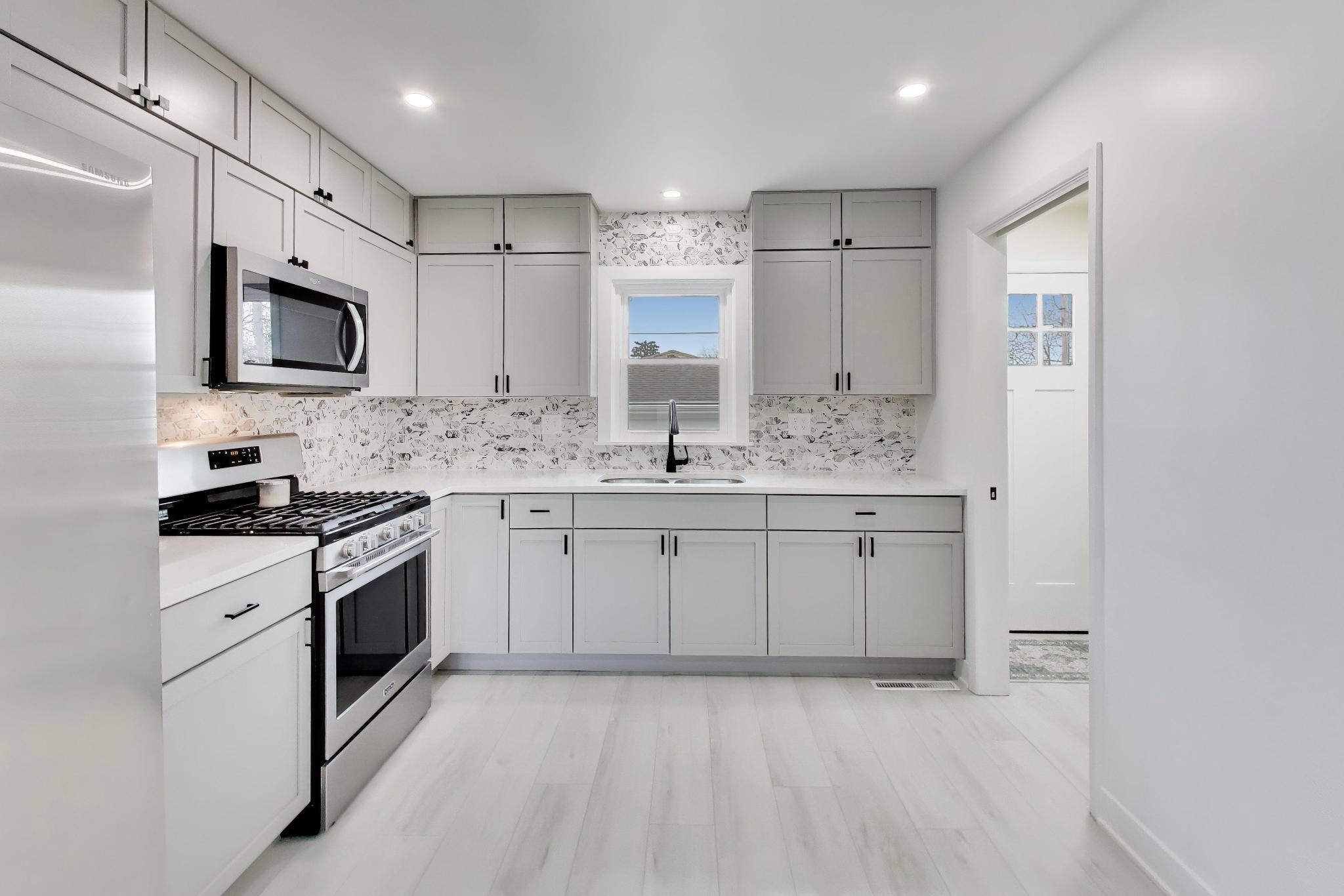 2022 38th Street Highland, IN 46322 - Photo 11 of 41 a kitchen with stainless steel appliances granite countertop a stove a sink and a microwave