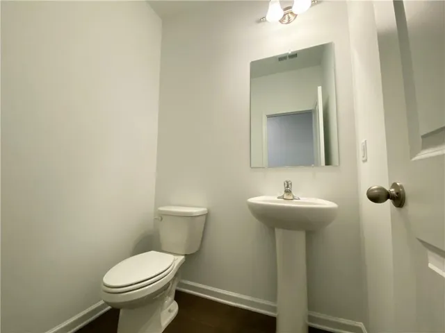 a bathroom with sink a toilet and mirror