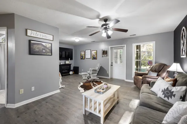 a living room with furniture and a ceiling fan