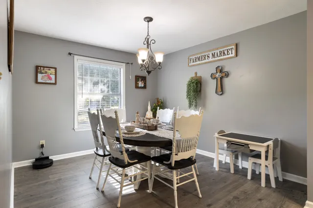 a dining room with furniture wooden floor a rug and a chandelier