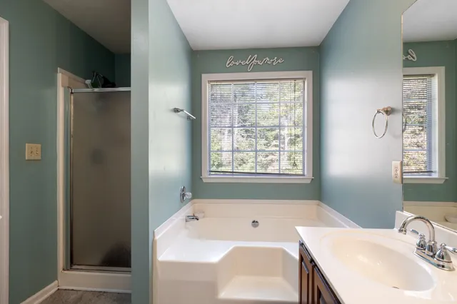 a bathroom with a tub a sink and a window