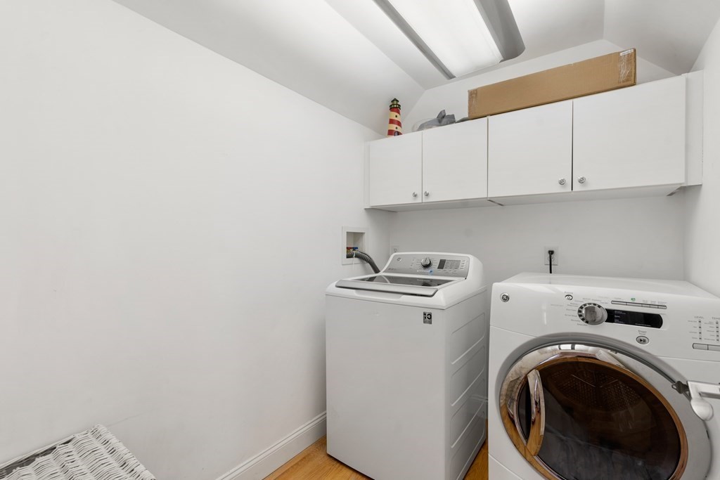 59 Elm Street Hingham, MA 02043 - Photo 22 of 33 a view of washer and dryer with kitchen in the background